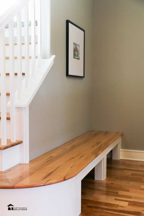 Wooden bench seat stretching around from staircase