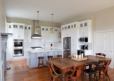 Farmhouse kitchen with white full overlay shaker cabinets and dove gray island