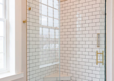Custom white subway tiled shower with gold accents